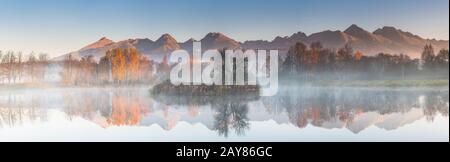 Ampio panorama cucito, riflesso autunnale nel lago, alba misteriosa Foto Stock