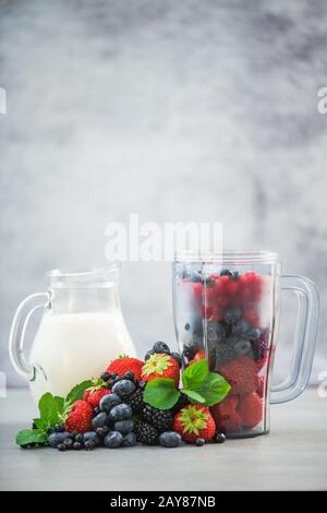 Frullatore con frutta e vaso di latte per frullati Foto Stock