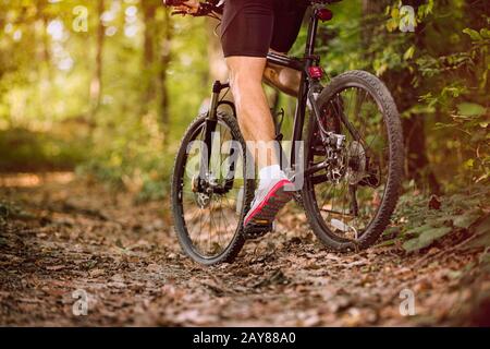 Extreme mountain bike uomo a cavallo su sentiero all'aperto nella foresta .Primavera, natura, concetto di sport Foto Stock