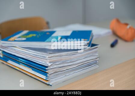 Stack di notebook per studenti sulla scrivania di un insegnante in classe Foto Stock