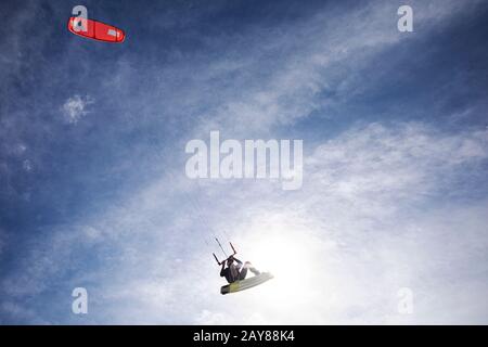 Età di ritiro kitesurfer maschio che effettua un volo alto vicino su questa tavola e aquilone in Florida in un giorno ventoso. Nessun LOGO. Stile di vita Foto Stock