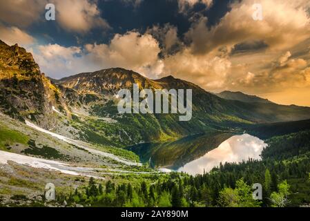 Cielo spettacolare all'alba sul lago alpino di Tatra Foto Stock