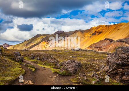 Viaggio in Islanda nel mese di luglio, tundra vulcanica estiva. Montagne multicolore di riolite - arancione, giallo, verde e blu Foto Stock