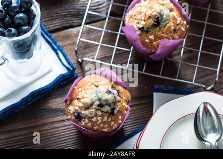 Muffin freschi di mirtillo serviti su tavolo di legno Foto Stock