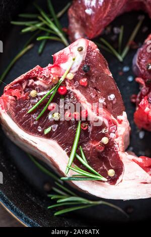 Costolette di agnello crudo con erbe di rosmarino fresco Foto Stock