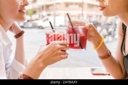 amici felici che graffiano il bicchiere dei cocktail sangria, bevande al bar Foto Stock