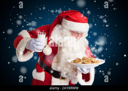 Babbo Natale è felice di latte e biscotti Foto Stock