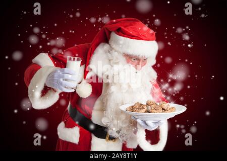 Babbo Natale è felice di latte e biscotti alla vigilia di natale. Foto Stock
