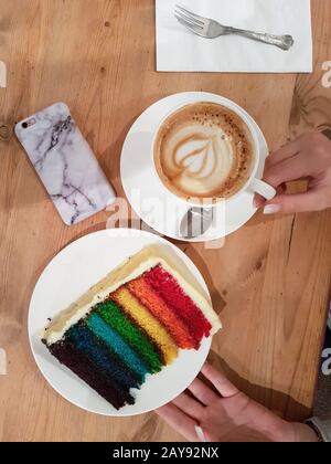 Tazza da caffè femmina con supporto a mano e piatto da torta Foto Stock