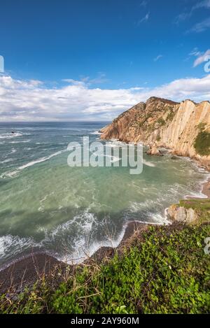 Bay e scogliere in El silenio beach, Cudillero, Asturias, Spagna. Foto Stock