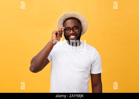 Close up ritratto di Giovane afro american scioccato tourist , tenendo la sua eyewear, indossando outfit turistica, cappello, con occhi spalancati Foto Stock