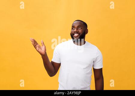 African American uomo con la barba che mostra le mani lontano lato isolato su sfondo giallo Foto Stock