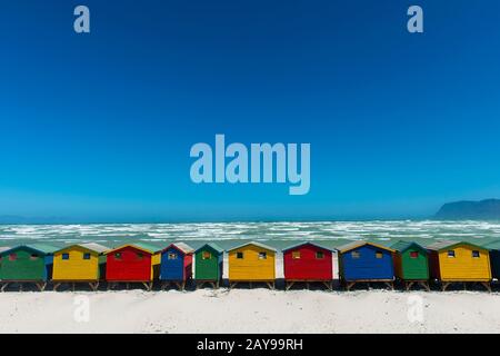 Vista delle colorate capanne che cambiano spiaggia sulla spiaggia di Muizenberg, un sobborgo a lato della spiaggia di Città del Capo, Sud Africa. Foto Stock