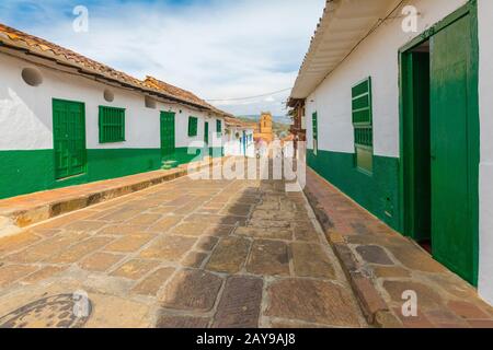 Quinta strada con case coloniali e cattedrale sullo sfondo Barichara Colombia Foto Stock