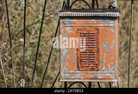 Vecchio weathered grunge rurale di metallo corroso casella postale su ferro porta giardino closeup Foto Stock