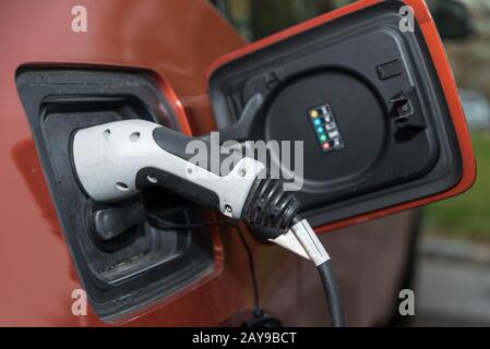 Rifornimento di elettricità presso un'auto elettrica presso una stazione di ricarica - primo piano Foto Stock