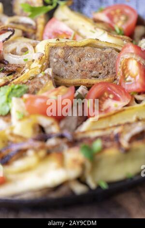 Maultasche svevo con cipolle in una padella di ferro Foto Stock