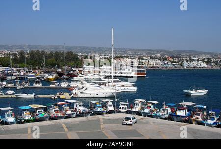 Vista aerea di barche da pesca e yacht ormeggiati nel porto di Paphos con gli edifici post e la città in Foto Stock