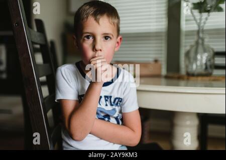 Giovane ragazzo succhiando Thumb al tavolo a Pajamas in Buda Texas Foto Stock