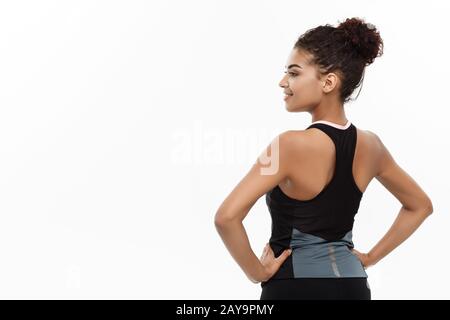 Concetto sano e di idoneità - Ritratto del giovane African Beautiful American mostrante il suo muscolo posteriore con la faccia allegra sicura Foto Stock