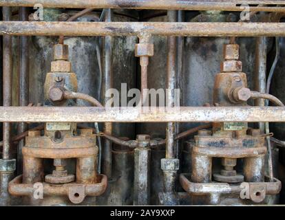 Primo piano di un vecchio grande motore diesel arrugginito con cilindri e tubi Foto Stock