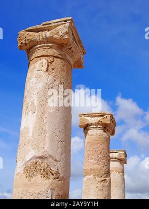 vecchie colonne romane alla luce del sole contro un cielo blu estivo con nuvole nel parco di kato paphos cipro Foto Stock