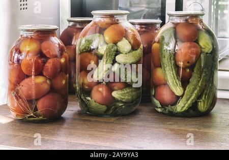 Conserve di pomodori e cetrioli in grandi vasi di vetro. Foto Stock