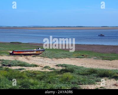 estuario ribble in lancashire con una piccola barca da pesca sul fiume e vecchio motoscafo derelict Foto Stock