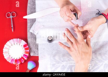 Tavolo da lavoro professionale per manicure con utensili da lavoro, applicazione di smalto per unghie in un salone per unghie donna. Foto Stock