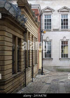 vecchi edifici su una strada acciottolata nel centro di rochdale guardando in discesa su un angolo acuto Foto Stock