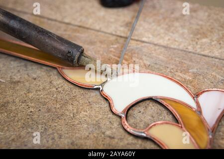 Il produttore di vetro colorato lavora con souvenir Foto Stock