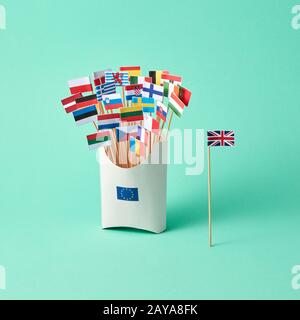 Bandiera della Gran Bretagna su carta e scatola di cartone con un segno dell'UE e diverse bandiere su sfondo verde con spazio per le copie. La e Foto Stock