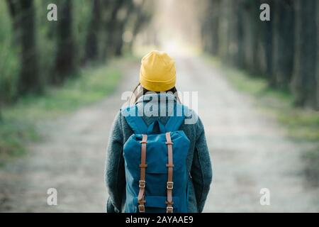 Giovane donna che cammina su un viale durante il suo viaggio. Foto Stock