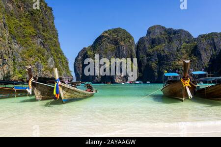 Barche a coda lunga sulla spiaggia di sabbia, l'isola di Phi Phi Lay Foto Stock