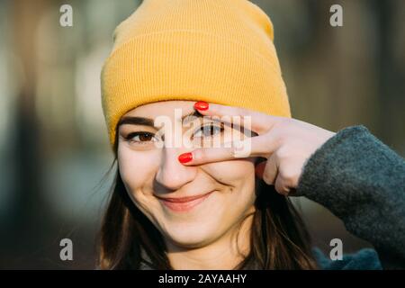 Giovane donna di gesti con le dita la messa a fuoco dell'occhio. Foto Stock