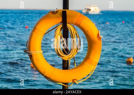 Lifebuoy appeso su un palo sul Mar Rosso Foto Stock