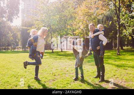 Famiglia a tema tempo libero all'aperto nella natura. Grande famiglia caucasica con quattro bambini. Mamma e papà si rilassano attivamente Foto Stock