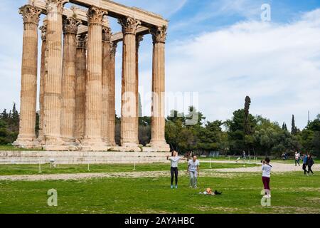 Turisti fotografati di fronte al tempio greco di Zeus Olimpio ad Atene Foto Stock