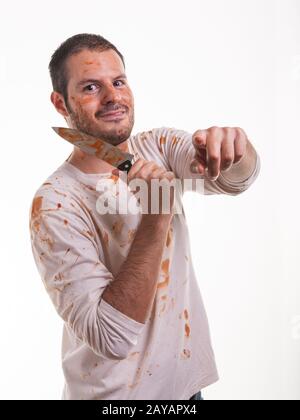 Una scena sanguinosa con un uomo e un coltello coperto di sangue in mano isolato su sfondo bianco. Violen Foto Stock