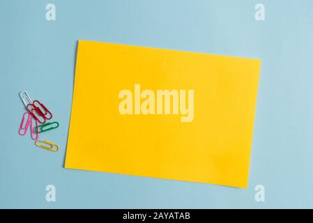 Semplice cartone e attrezzatura di scrittura posto sopra sfondo pastello. Carta più bastone fisso a sfondo moderno e senza motivi Foto Stock