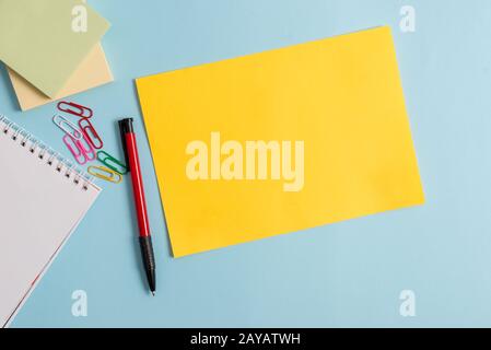 Semplice cartone e attrezzatura di scrittura posto sopra sfondo pastello. Carta più bastone fisso a sfondo moderno e senza motivi Foto Stock