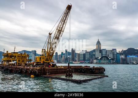 Sognando nel porto di Hong Kong, scavando fango, erbacce e rifiuti Foto Stock