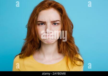 Headshot Ritratto di tenera ragazza adolescente redhead con espressione seria guardando la macchina fotografica. Donna caucasica modello con zenzero ha Foto Stock