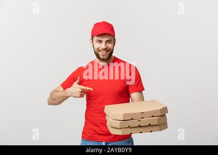 Concetto di consegna: bello caucasian Pizza consegna uomo puntare il dito. Isolate su uno sfondo grigio. Foto Stock