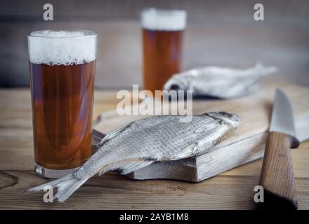 Due bicchieri di birra e pesce essiccati . Foto Stock