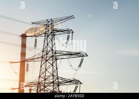 power trasmissione torre e camino al crepuscolo Foto Stock