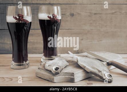 Due bicchieri di birra e pesce essiccati . Foto Stock