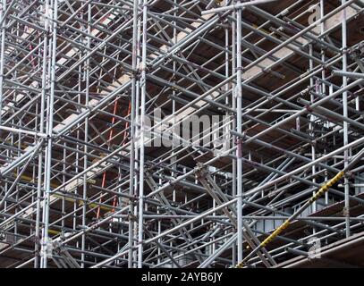 una fitta rete di pali per ponteggi metallici che supportano piattaforme di lavoro in un cantiere Foto Stock