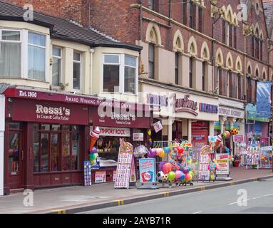 una fila di negozi neville street a southport merseyside vendere gelati rock beach giocattoli snack e candyfloss con e divertimento Foto Stock