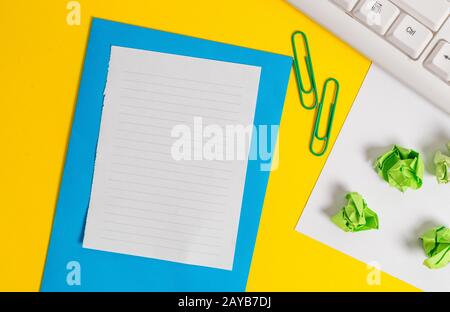 Disposizione piatta sopra lo spazio di copia vuoto carta bianca con graffette sul tavolo. Concetto di business con white paper vuoto sulla scrivania. Foto Stock